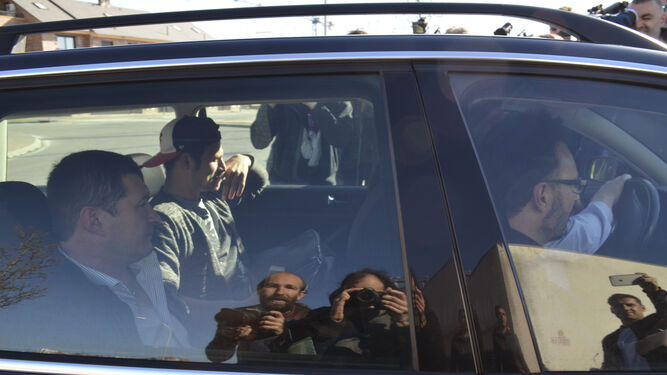 Zozulya junto a sus agentes en el coche rodeado de periodistas.
