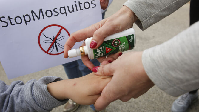 Una madre aplica repelente de mosquitos a un niño en Guadalmar.