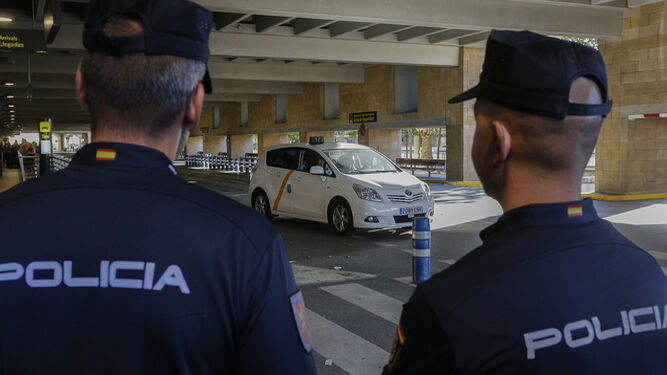 Dos policías nacionales observan un taxi en el aeropuerto de San Pablo.