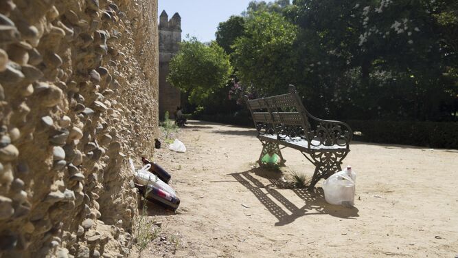 Restos de una 'botellona' junto al tramo de muralla almohade que rodea los jardines. La foto está realizada a las 11:30. / JULIÁN VENEGAS