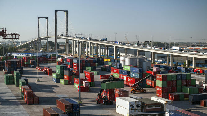 La terminal de contenedores del Puerto  de Sevilla, donde paran los trenes de mercancías, con el Puente del Centenario al fondo.
