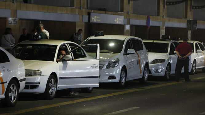 Taxistas esperando en la parada del aeropuerto.