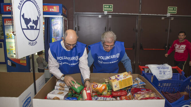 Dos voluntarios organizan alimentos de la gran recogida del año pasado.