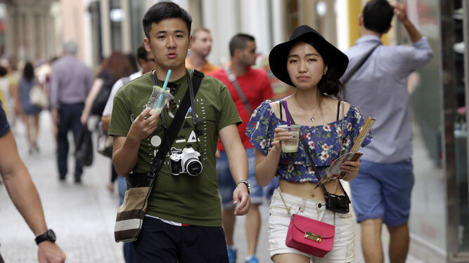 Dos turistas de origen asiáticos por las calles del centro de la ciudad.