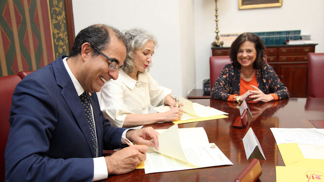 El rector de la US, Miguel Ángel Castro, firmando el acuerdo con Rosario Domínguez, de la empresa Curadas de Espanto.