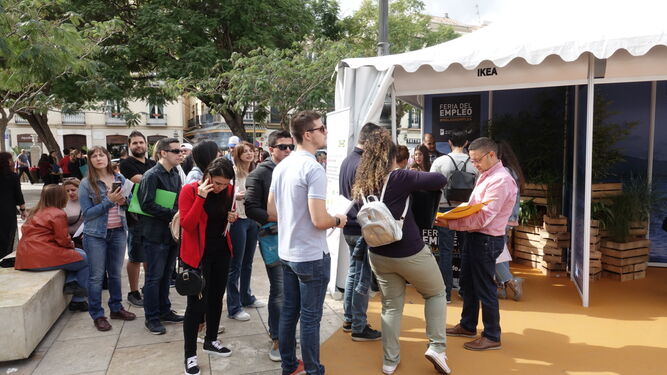Varios aspirantes hacen cola en uno de los puestos de la Feria de Empleo en la Plaza de la Merced