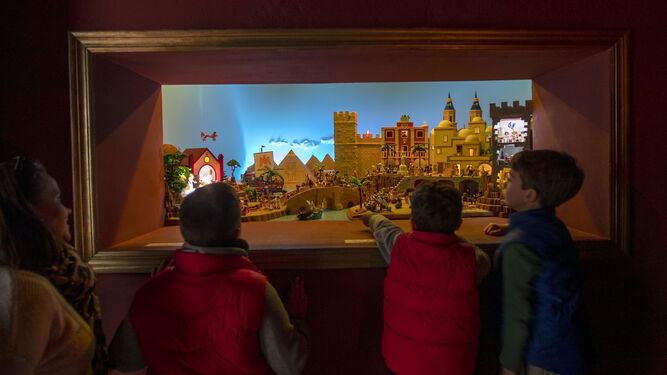 Varios niños contemplan el belén de Playmobil instalado por la hermandad de la Soledad.