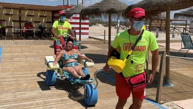 Una usuaria del módulo 5 Estrellas de la playa de Camposoto haciendo uso de la silla anfibia.