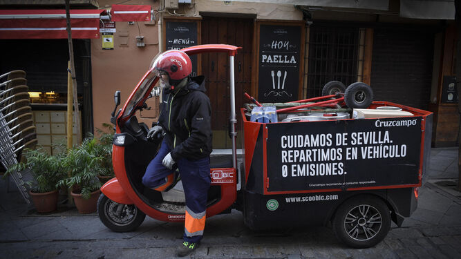 El repartidor de Cruzcampo llega a uno de los establecimientos en su vehículo eléctrico.