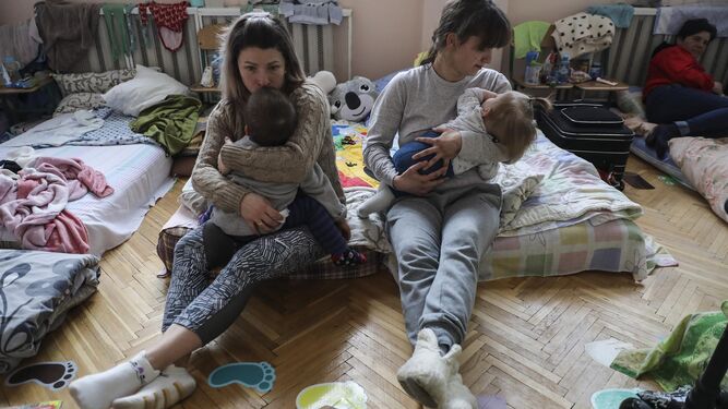 Dos madres y sus hijos descansan en una escuela infantil en Pustomyty, cerca de Leópolis, en el oeste de Ucrania, habilitada como refugio.