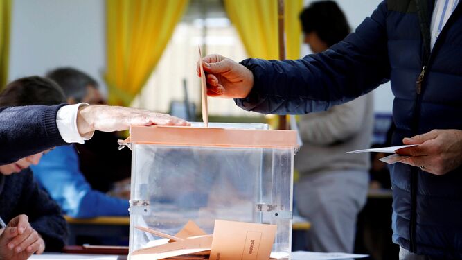Una persona depositando un voto en la urna