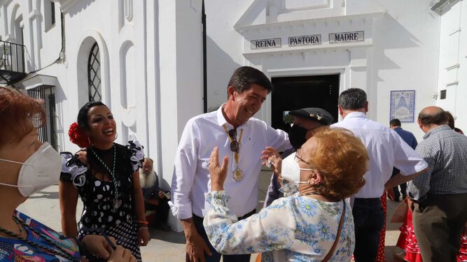 Juan Marín conversa con una mujer a la salida del Santuario del Rocío.