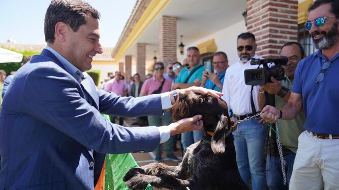 Moreno acaricia a un perro tras su encuentro con dirigentes de la Federación Andaluza de Caza.
