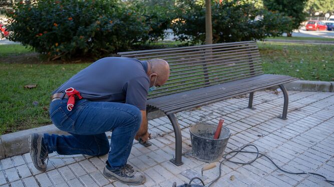 Un operario realiza labores de mantenimiento en un banco de un parque de San Fernando, en una imagen de 2020.