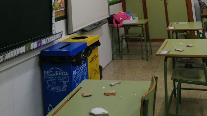 Cascotes del techo en las mesas del aula del colegio, tras el desprendimiento.