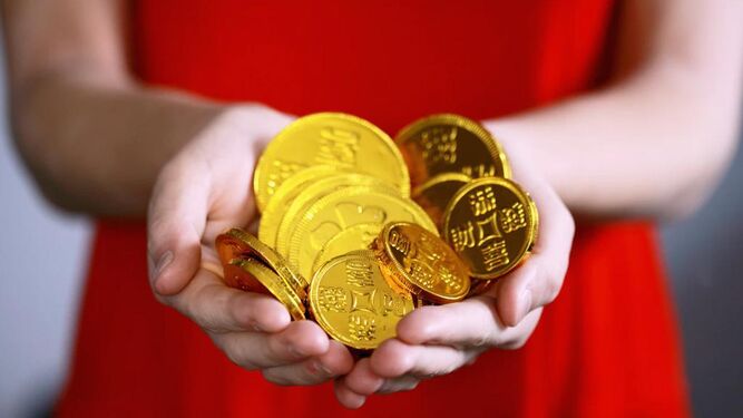 Una mujer porta en sus manos monedas chinas