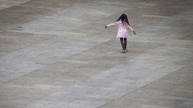 Una niña juega con un charco.