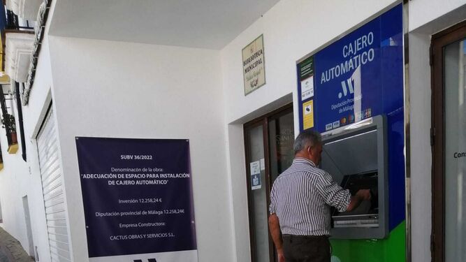 Un hombre opera un cajero automático en un pueblo de la provincia de Málaga.