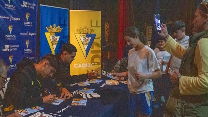 Los jugadores del filial Luis Morales y Adri Salguero firman fotografías.