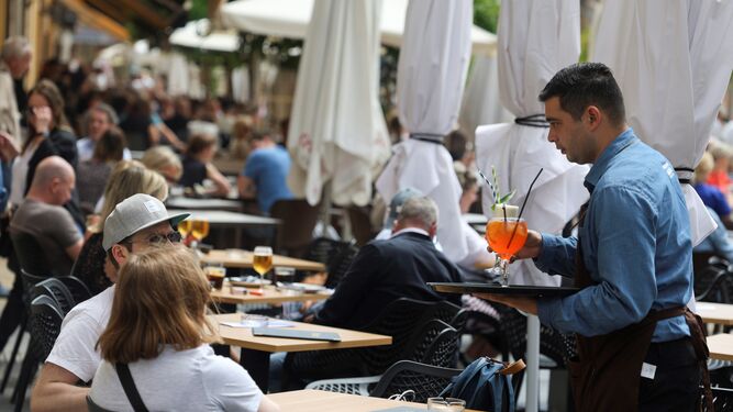 Un camarero atendiendo a unos clientes en Málaga.